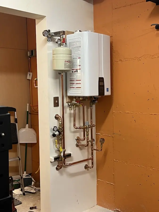 Plumbing technician inspecting water heater connections in Upper Merion